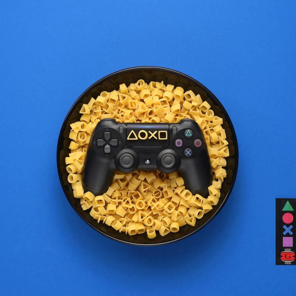 Fotoritoccatore Ritoccatore Fotoritocco Ritoccatrice plate with a playstation 4 controller inside covered by pasta by pasta garofalo, special pasta size for playstation it