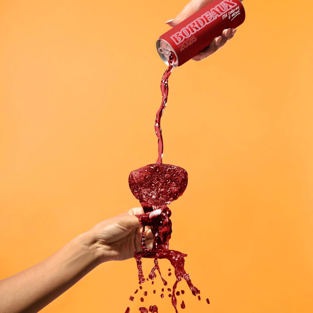 Lattina di vino con versata del vino stesso su un bicchiere